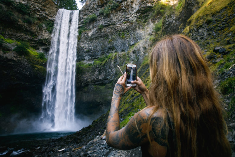 Cute girl smoking cannabis by waterfall
