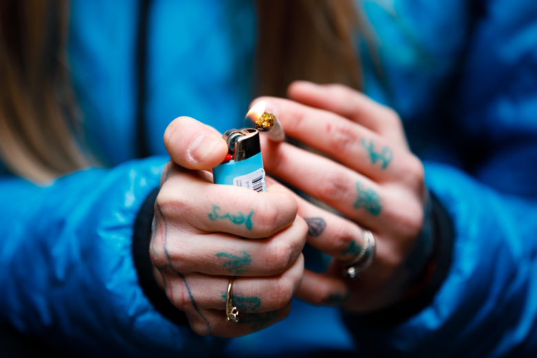 Cannabis lifestyle photography: Cute girl smoking cannabis in nature